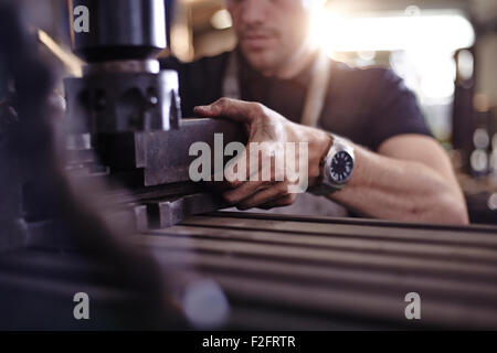 Close up mechanic using machinery in auto repair shop Stock Photo