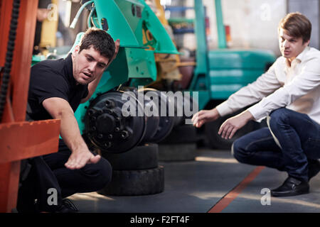 Mechanic and customer talking in auto repair shop Stock Photo