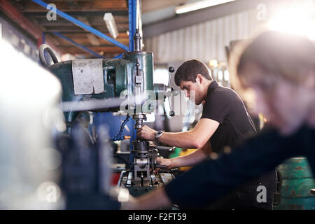 Mechanics using machinery in auto repair shop Stock Photo