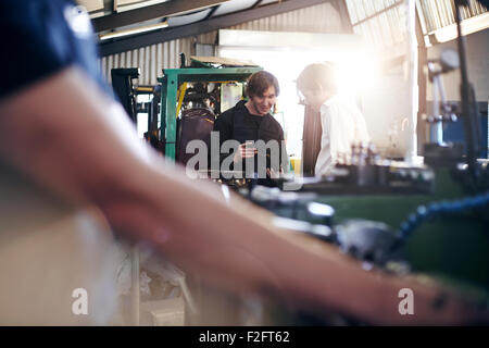 Mechanic and customer talking in auto repair shop Stock Photo