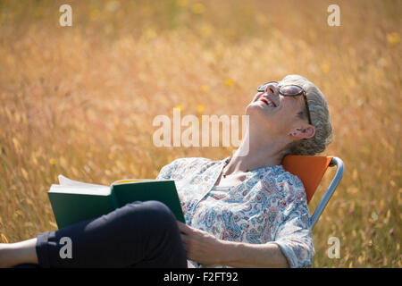 A woman with her head leaning back laughing uncontrollably Stock Photo