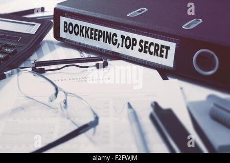 Bookkeeping,Top Secret - Ring Binder on Office Desktop with Office Supplies. Business Concept on Blurred Background. Toned Illus Stock Photo