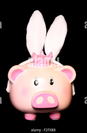 Piggy bank wearing rabbit ears cutout Stock Photo