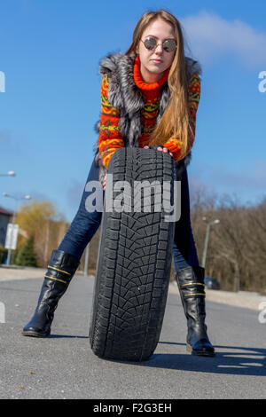 Female biker rolls big wheel Stock Photo