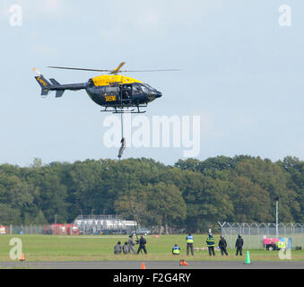 Dunsfold Aerodrome, Surrey, England, UK. 17th September 2015. Metropolitan Police helicopter, with personnel practicing descent training known as Fast Roping . Credit:  Tony Watson/Alamy Live News Stock Photo