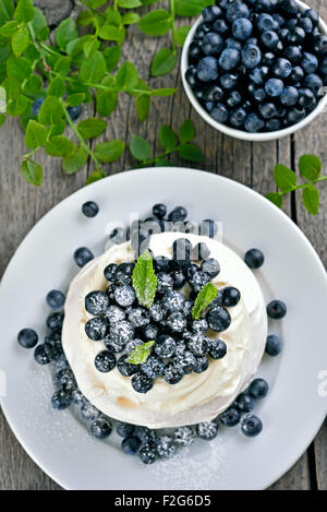 Homemade pavlova meringue cake with fresh berries on wooden rustic table, top view Stock Photo