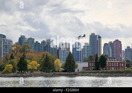 Sea Plane coming into land over downtown Vancouver with HMCS Discovery on Deadman's Island in the foreground Stock Photo