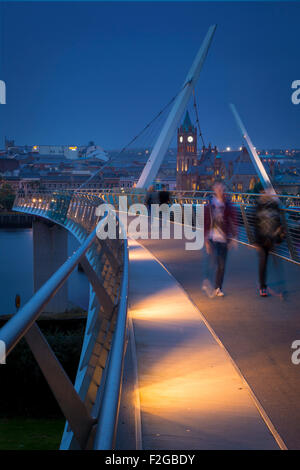Walkers along the Peace Bridge and skyline of Londonderry/Derry, County Londonderry, Northern Ireland, UK Stock Photo
