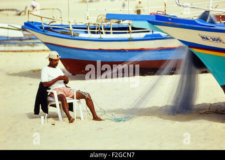 Local fisherman mending his nets. Hammamet. Tunisia. North Africa. Stock Photo