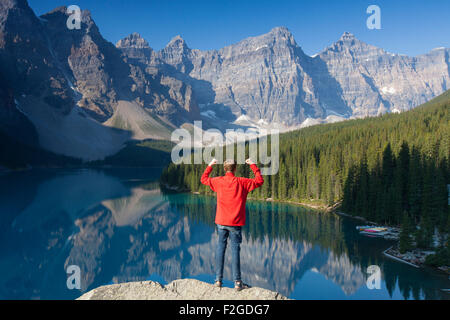 Tourist with open arms on look-out point looking over Moraine Lake in the Valley of the Ten Peaks, Banff NP Alberta, Canada Stock Photo