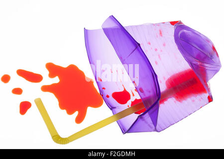 smashed translucent purple cup with  yellow straw with red liquid spilling out on white light box Stock Photo