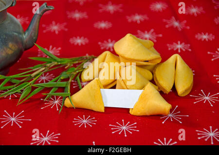 Bamboo shoots with fortune cookies on red fabric with antique tea pot. Stock Photo