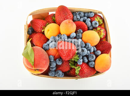 Mellow fresh summer strawberries, blueberries, apricots and peach in wooden basket isolated on white background, top view Stock Photo