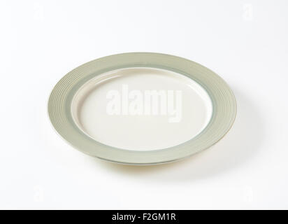 Charger plate with wide grey rim decorated with a pattern of subtle rings Stock Photo