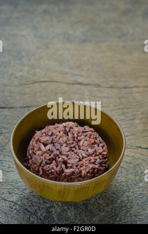 Cooked rice of Riceberry in brown bowl on wooden table Stock Photo