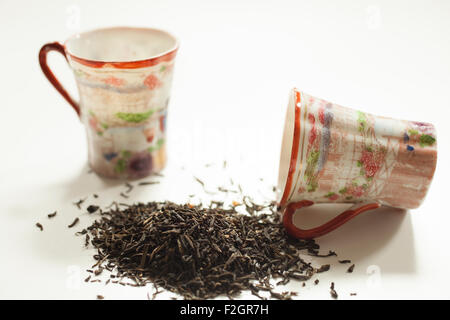 A pile of black tea with two small china cups. Stock Photo