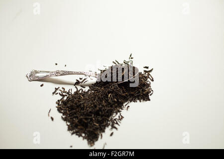 A pile of black tea with a silver teaspoon. Stock Photo