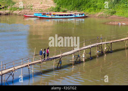 Tourists on bamboo bridge across Nam Khan river, Luang Prabang, Laos Stock Photo