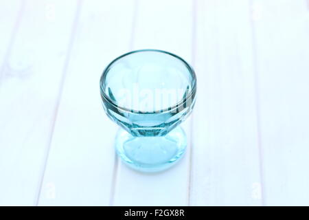 Empty blue glass bowl on white timber board Stock Photo