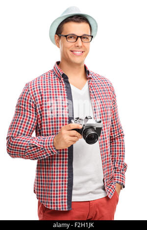 Vertical shot of a young male photographer in artistic clothes holding a camera isolated on white background Stock Photo