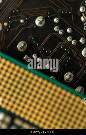 Close-up defocused Macro image of a computer's CPU Central Processing Chip resting on a PCB motherboard background Stock Photo