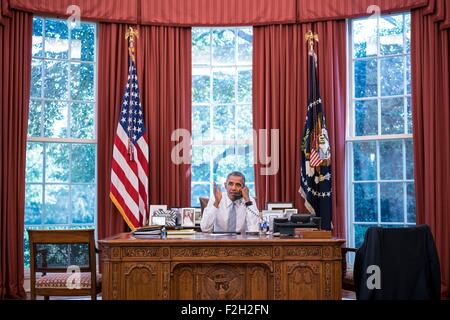 Washington DC, USA. 18th September, 2015. US President Barack Obama talks on the phone with Cuba President Raul Castro from the Oval Office of the White House Sept. 18, 2015 in Washington, DC. Stock Photo