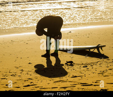 Seaton Carew, UK. 19th September, 2015. Weather: Surfer heading out just after sunrise on Seaton Carew beach Stock Photo