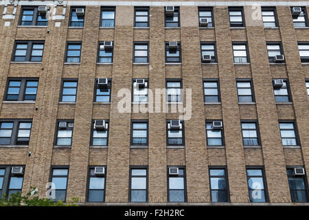 The outside of a building in America. Large amounts of air conditioners can be seen on the windows. Stock Photo