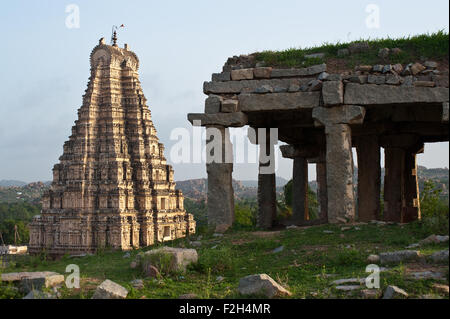 'Gopuram' of the Virupaksha temple at Hampi. In the foreground, a ruin. ( India) Stock Photo