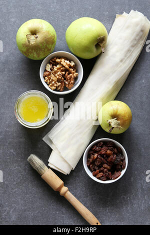 Ingredients for making apple strudel.Apple,raisins,walnuts,filo pastry and butter Stock Photo