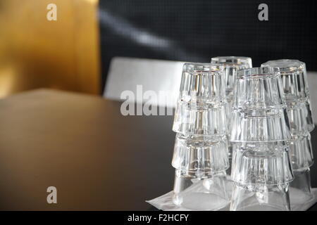 Clean drinking glasses stacked on a black table in a cafe. Stock Photo