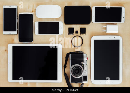 Collection of digital tools of a photographer, with camera, cards, and tablets on a wooden desk Stock Photo