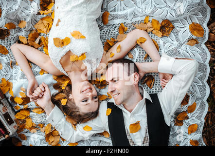 wedding couple lying under a tree Stock Photo