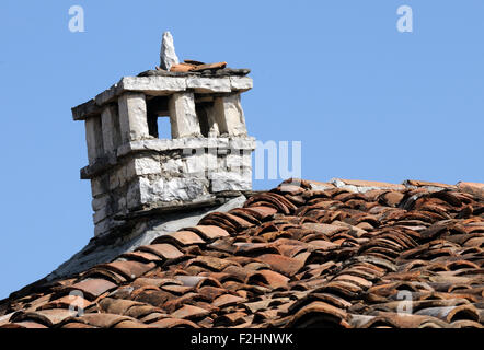 A stone chimney stands over a tiled roof in  Berat Castle.  Berat, Albania. Stock Photo