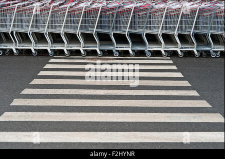 Rows of shopping carts outside store patterns of metal with crosswalk Stock Photo