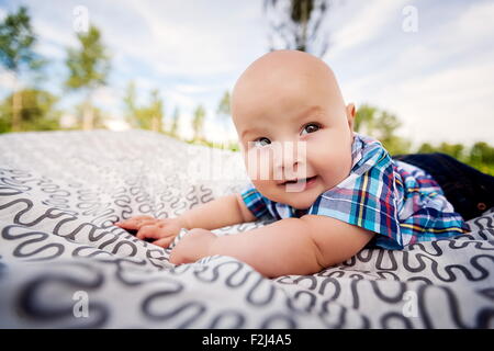 little boy in plaid shirt lying on blankets. Stock Photo
