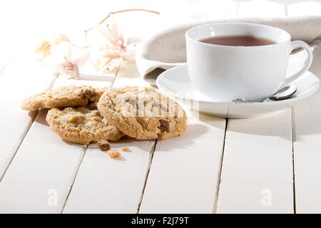 crispy cookies with chocolate and nuts on a white wooden table Stock Photo