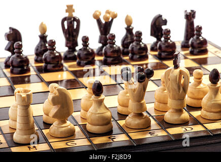 Wooden chess pieces lined up on a board ready to play a game or match Stock Photo