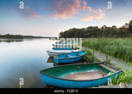 Boats moored to an old wooden jetty at Filby Broad on the Norfolk Broads near Great Yarmouth Stock Photo