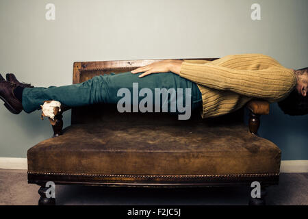 Young man lying on sofa Stock Photo