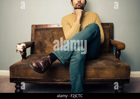 Thoughtful young man on sofa Stock Photo
