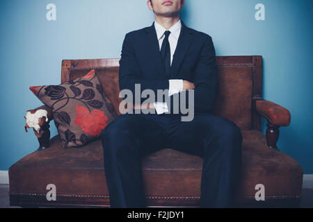 Confident young businessman on sofa Stock Photo