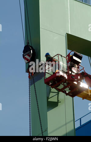 Two Worker installing a metal bridgehead in a harbor Stock Photo