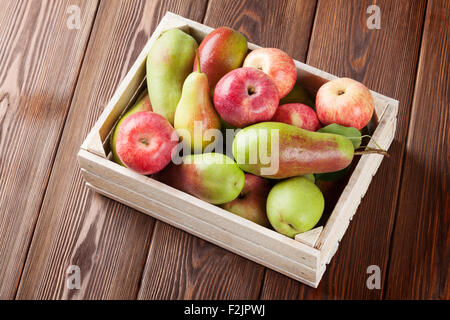 Pears and apples in wooden box on table Stock Photo