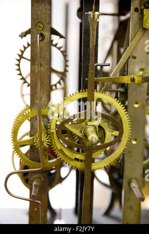 Close up view of greasy and rusty old wall clock mechanism with gears, isolated on white background Stock Photo