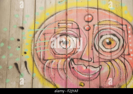 Detail of street art. Colourful graffiti of a sunny smiling face painted on a window shutter by the artist known as Loko. Montpellier, South of France. Stock Photo