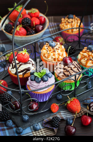 Set of different delicious cupcakes on dark Stock Photo