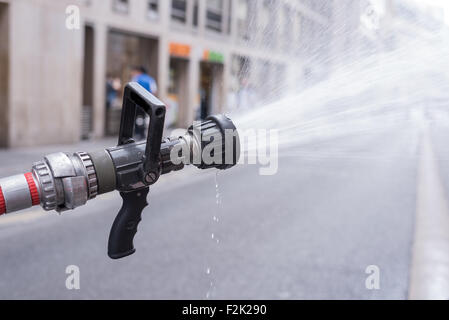 Water jet splashing from a fire fighting firehose nozzle Stock Photo