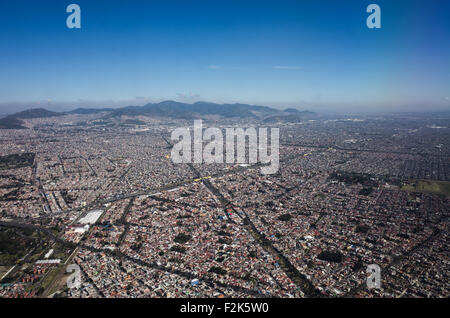 An aerial view of Mexico unfolds beneath the plane, revealing a diverse tapestry of landscapes. From rugged mountain ranges and sprawling deserts to lush forests and winding coastlines, this bird's-eye perspective showcases the country's rich geographical variety. Cities and rural areas alike punctuate the terrain, offering a stunning visual representation of Mexico's natural beauty and human development. Stock Photo