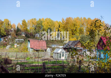 Small cottages in colorful forest at fall time Stock Photo
